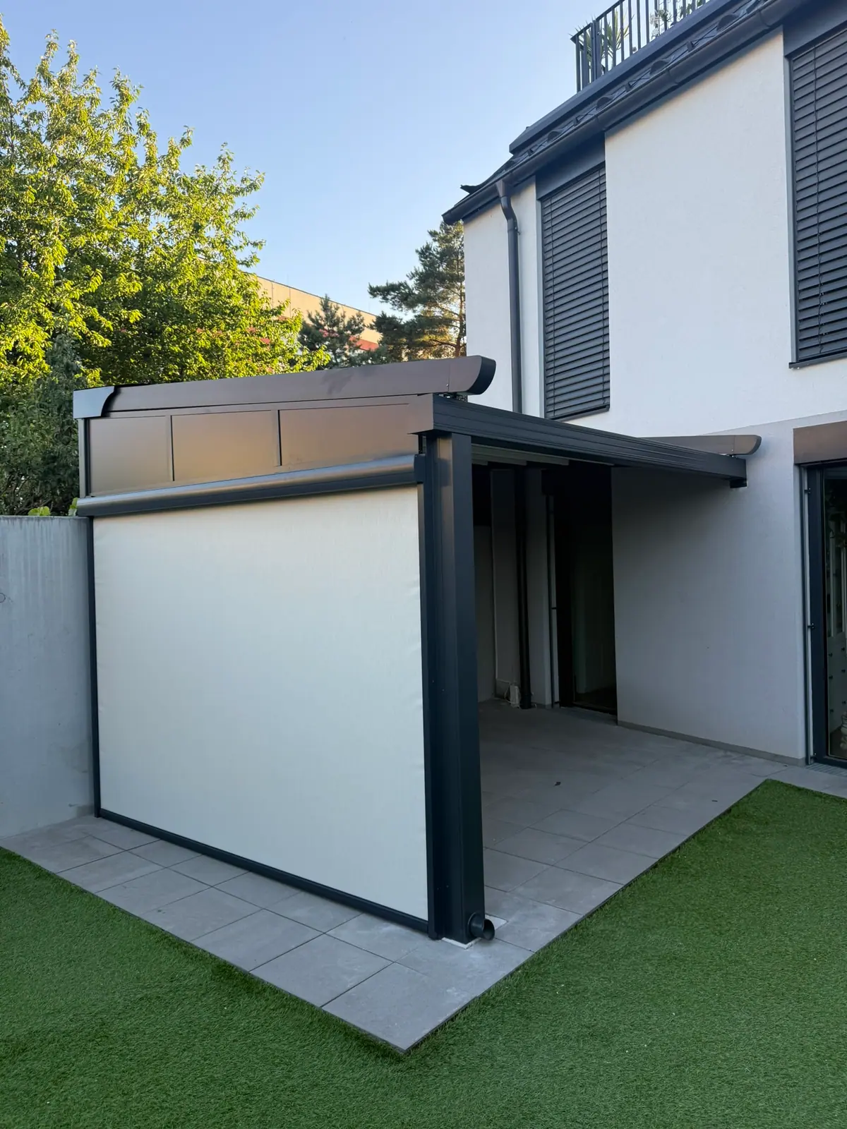 Faltdach-Pergola mit seitlicher Senkrechtmarkise an einem Reihenhaus