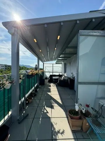 Faltdach-Pergola über einer Dachterrasse mit Blick über die Stadt
