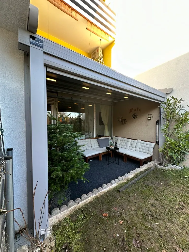 Faltdach-Pergola über einem Sitzplatz im Garten