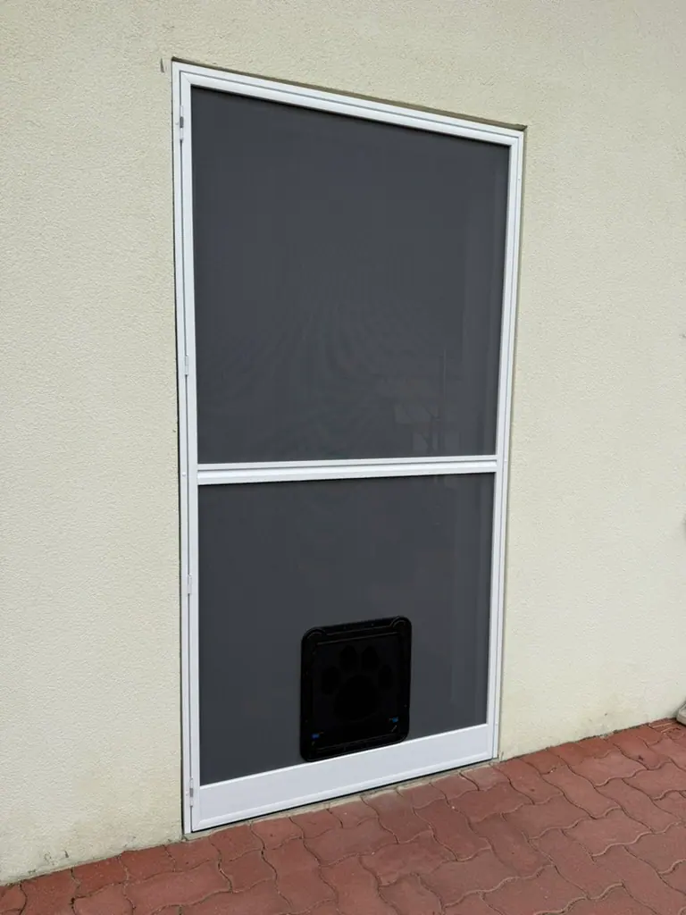 Fliegengitter mit Katzenklappe an einer Fenstertür