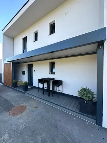 Lamellendach entlang der Fassade eines Wohnhauses