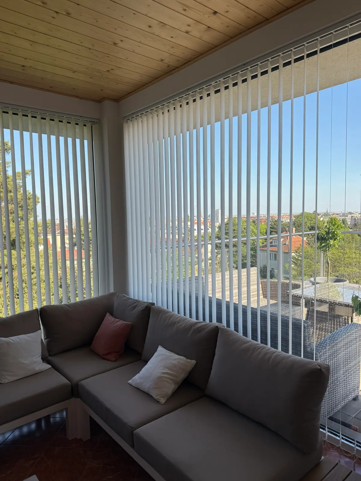 Lamellenvorhang an großen Fenstern neben einer Sitzecke