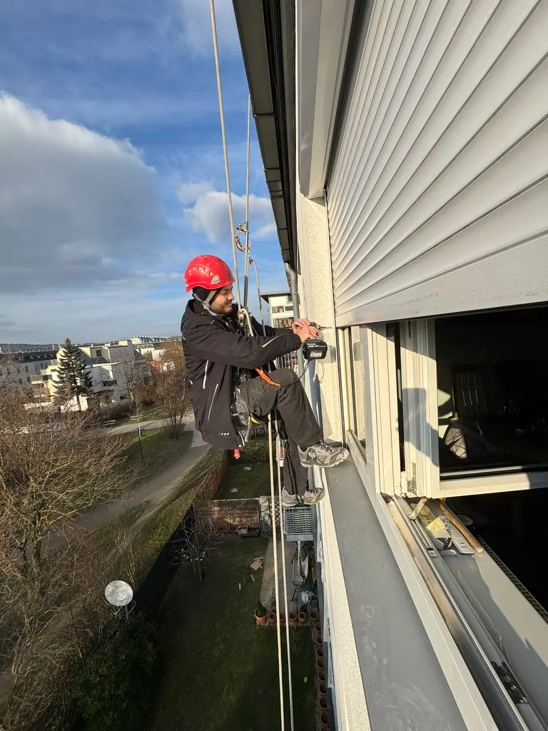 Monteur beim Einbau eines Rollladens an der Fassade