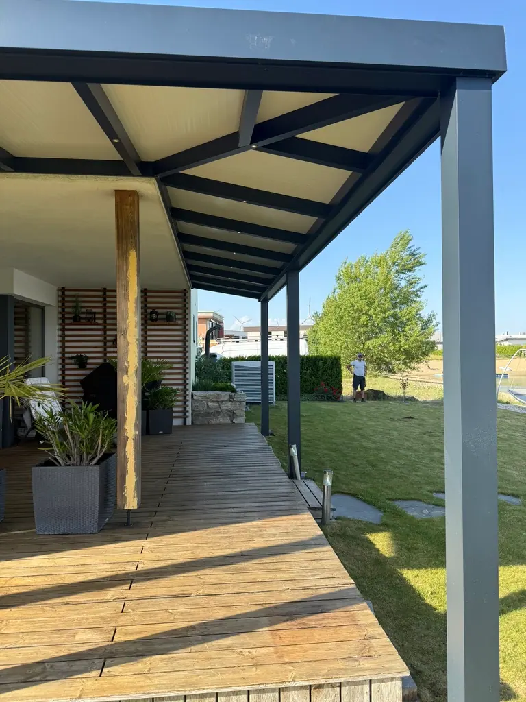 Überdachte Holzterrasse mit Paneeldach und Aluminiumstützen