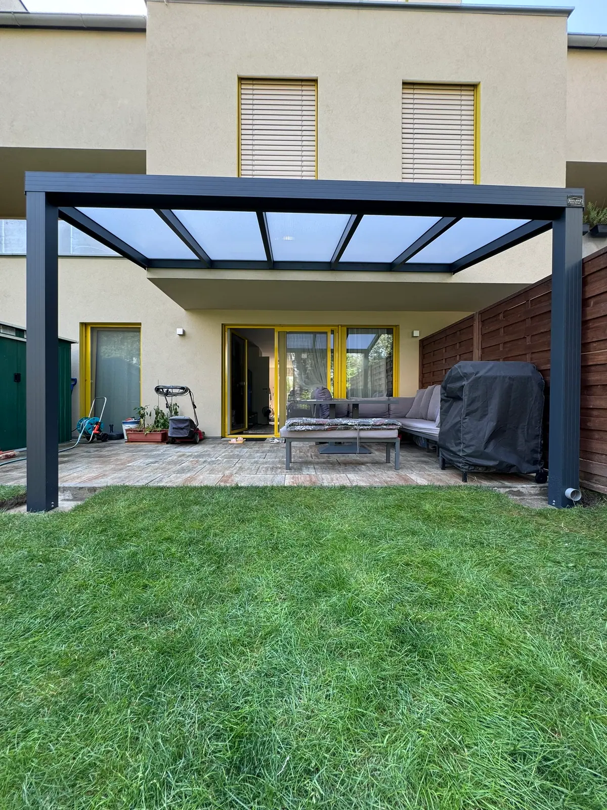 Überdachung mit Stegplatten über einer Terrasse an einem Reihenhaus