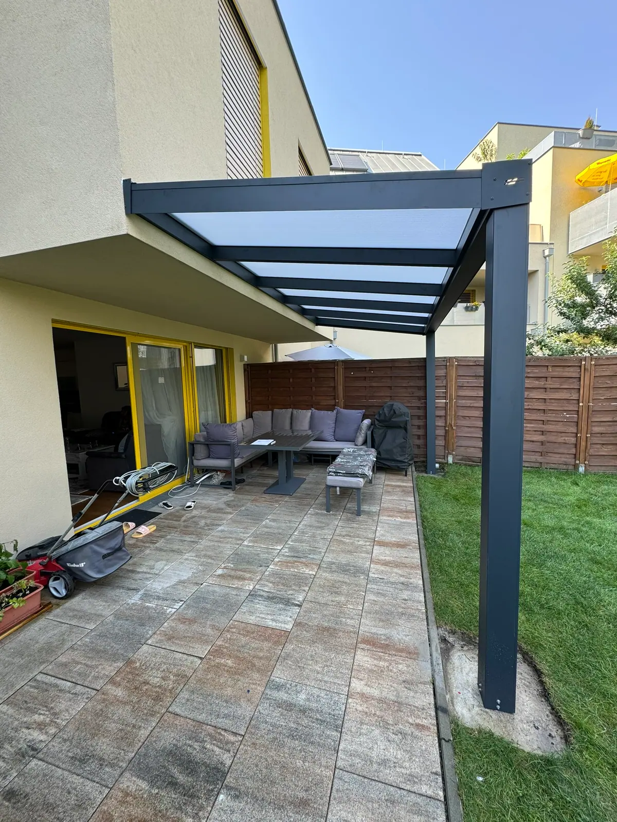Überdachung mit Stegplatten über einer Terrasse mit Holzzaun