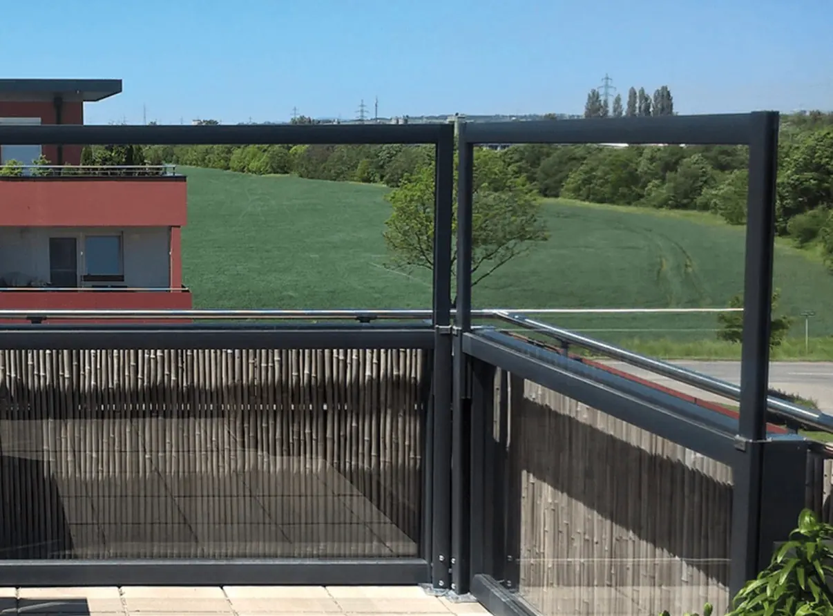 Windschutz aus Glas auf einer Dachterrasse mit Blick ins Grüne