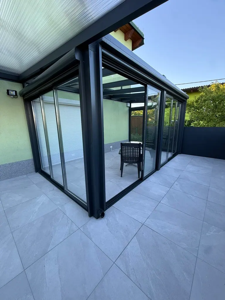 Wintergarten mit Glasschiebewänden in Anthrazit auf einer Terrasse